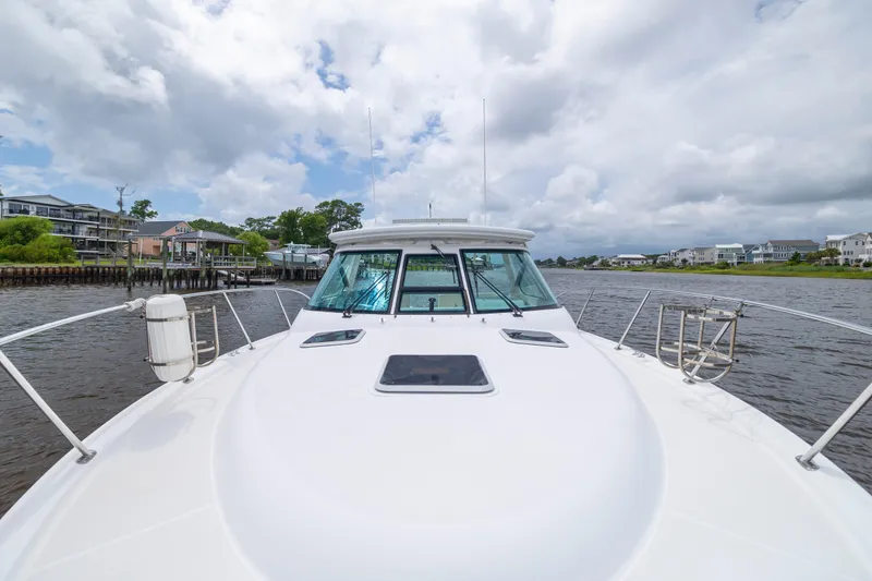 Slide: The Image of 2004 Tiara Yachts 3200 Open cruising on a scenic waterway under cloudy skies. - 24