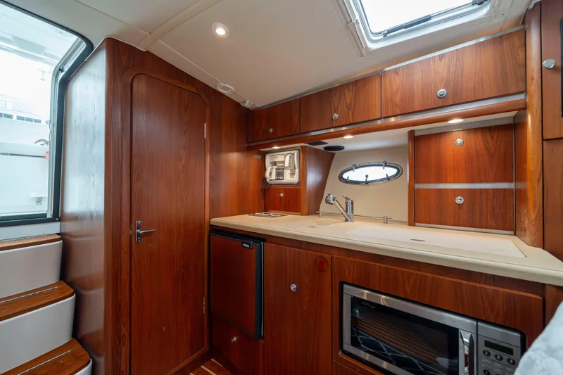 Slide: The Image of Luxurious 2004 Tiara Yachts 3200 Open interior with wood cabinetry and modern amenities. - 31