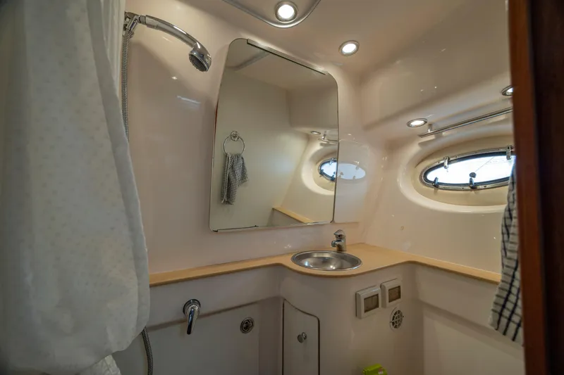 Slide: The Image of 2004 Tiara Yachts 3200 Open bathroom with sink, mirror, and porthole window. - 32