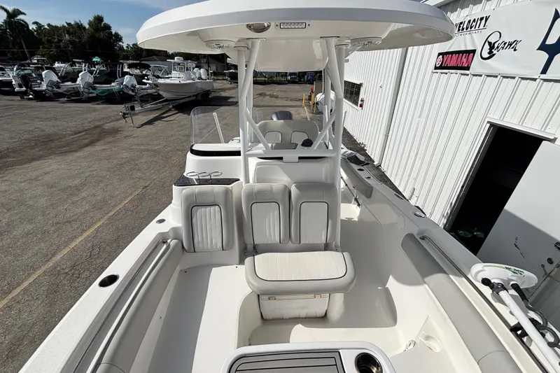 Slide: The Image of 2021 Sea Fox 249 Avenger boat interior with seating and console, docked at a marina. - 14