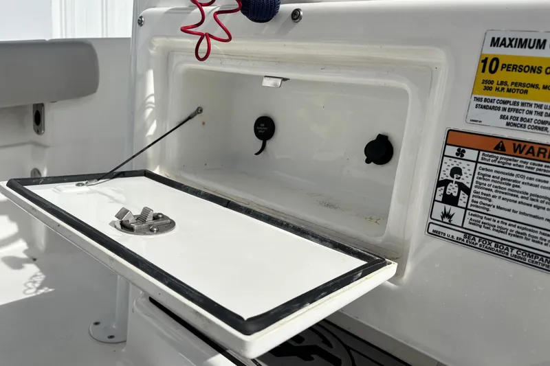 Slide: The Image of 2021 Sea Fox 249 Avenger boat storage compartment with safety warnings and capacity details. - 22