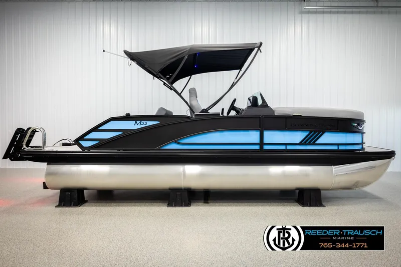 Slide: The Image of 2026 Bennington 22 MSBSE pontoon boat with blue accents and canopy in showroom. - 5