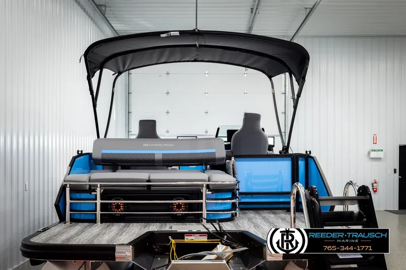 Slide: The Image of 2026 Bennington 22 MSBSE pontoon boat in showroom, featuring sleek design and modern seating. - 7