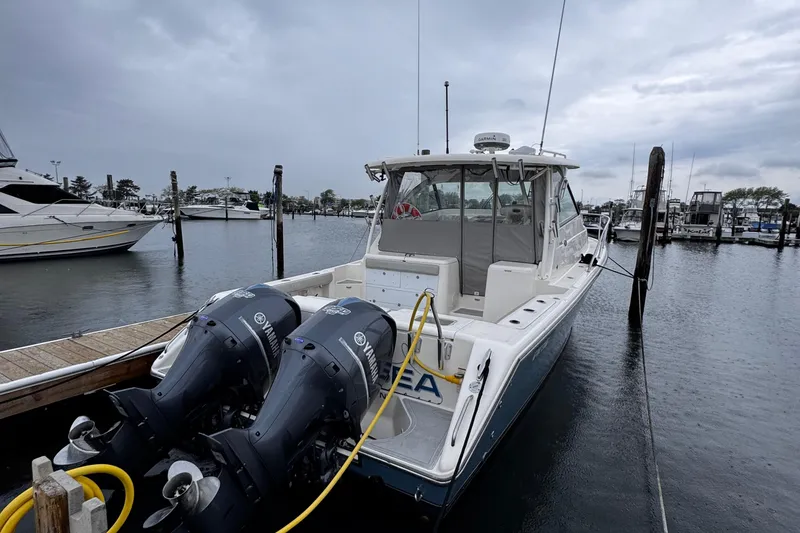 Slide: The Image of 2011 Pursuit OS 345 Offshore boat docked with dual Yamaha engines in a marina. - 10