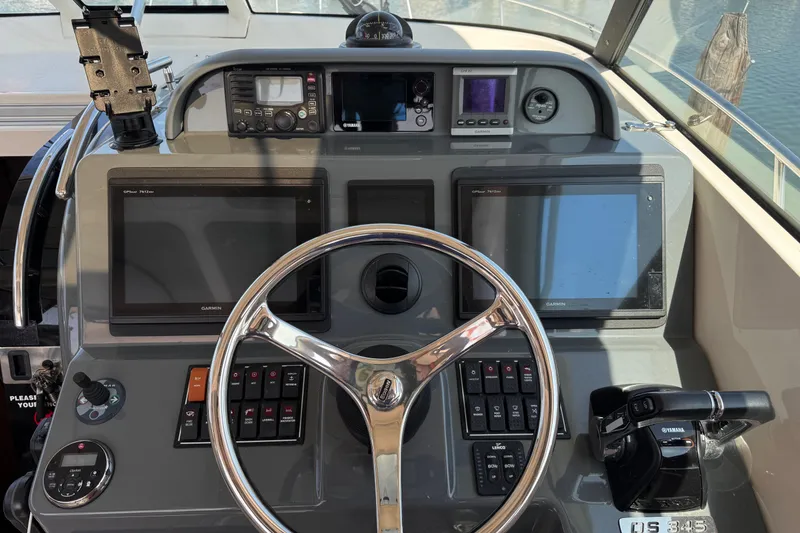 Slide: The Image of Control panel of 2011 Pursuit OS 345 Offshore boat with navigation screens and steering wheel. - 13