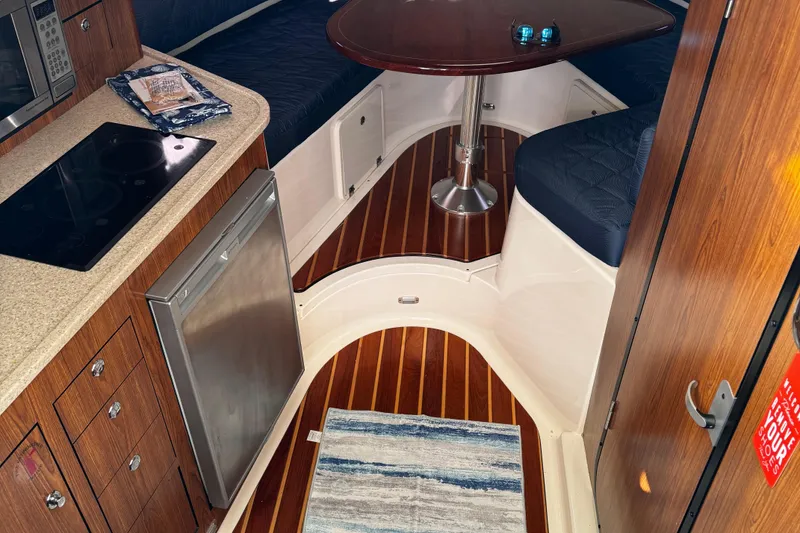 Slide: The Image of 2011 Pursuit OS 345 Offshore cabin interior with kitchenette and seating area. - 17