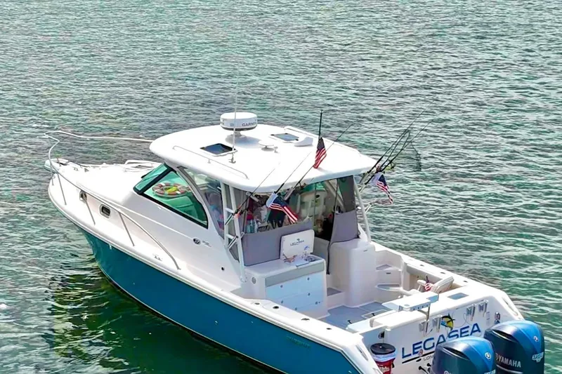Slide: The Image of 2011 Pursuit OS 345 Offshore boat on water, equipped with fishing rods and flags. - 2