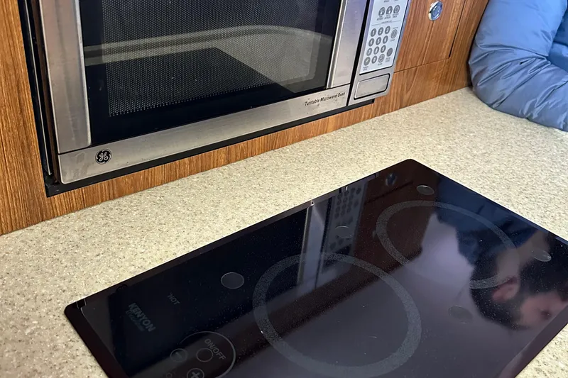 Slide: The Image of Microwave and stovetop in 2011 Pursuit OS 345 Offshore boat kitchen. - 24