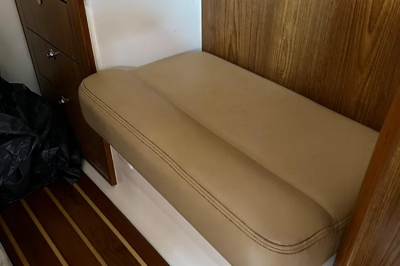 Slide: The Image of 2011 Pursuit OS 345 Offshore interior with beige cushioned seating and wooden cabinetry. - 26