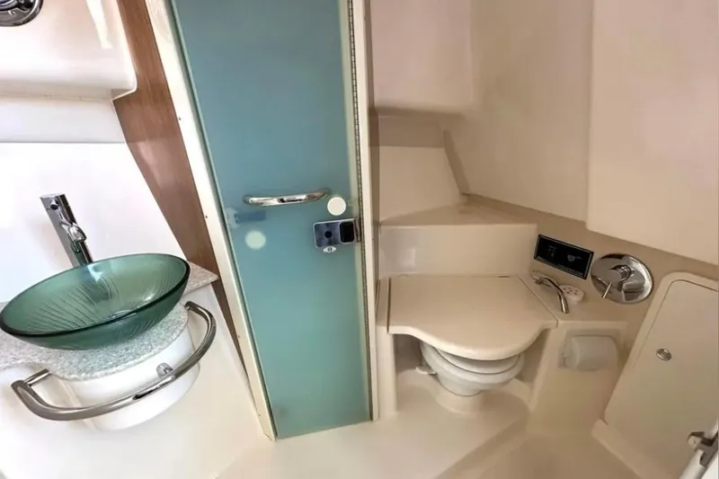 Slide: The Image of 2011 Pursuit OS 345 Offshore boat bathroom with glass sink and modern fixtures. - 30