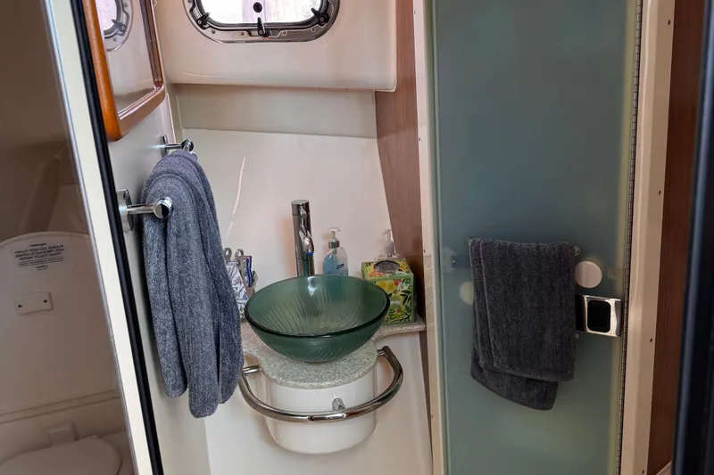 Slide: The Image of 2011 Pursuit OS 345 Offshore bathroom with glass sink and modern fixtures. - 35