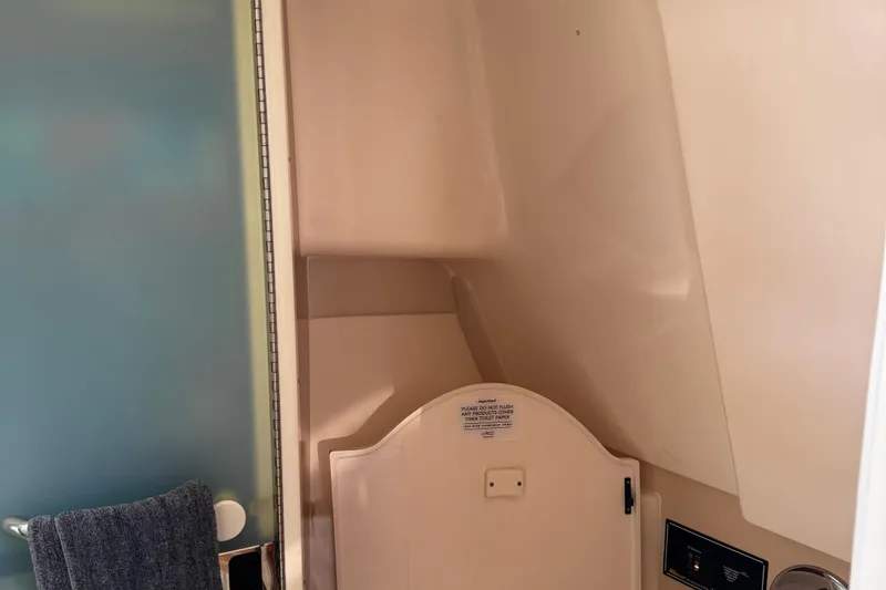 Slide: The Image of Interior of 2011 Pursuit OS 345 Offshore boat bathroom with towel and toilet. - 36