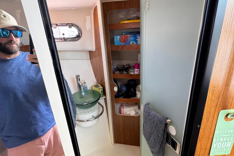 Slide: The Image of Interior of 2011 Pursuit OS 345 Offshore boat bathroom with sink and storage shelves. - 37