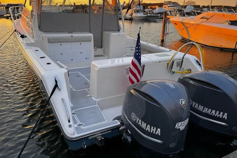 Slide: The Image of 2011 Pursuit OS 345 Offshore boat with Yamaha engines docked at sunset. - 6