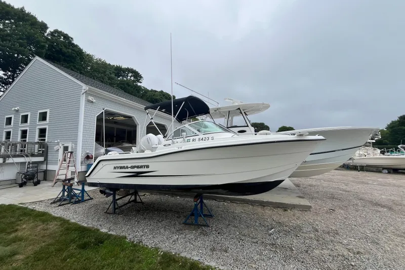 Slide: The Image of 2002 Hydra-Sports 202 DC boat on stands near a boathouse. - 0