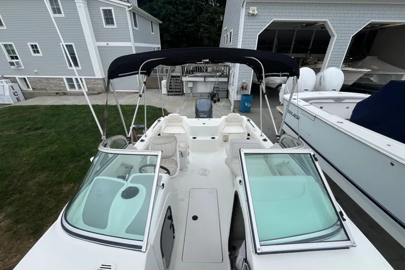 Slide: The Image of 2002 Hydra-Sports 202 DC boat with canopy, docked near gray buildings. - 11