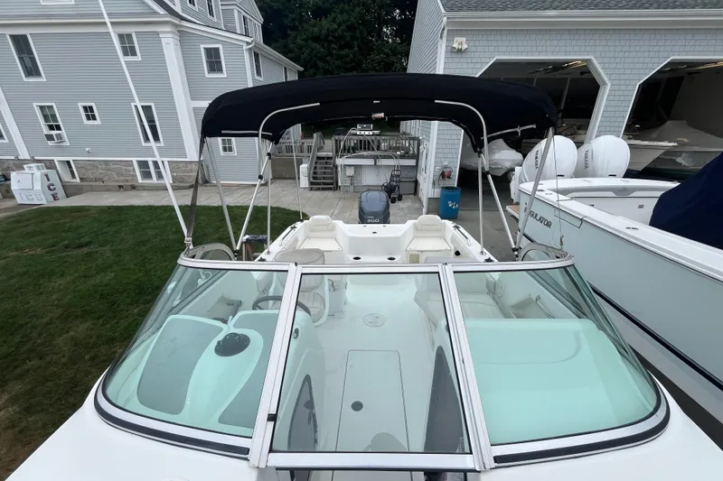 Slide: The Image of 2002 Hydra-Sports 202 DC boat with canopy, docked near a gray building. - 12