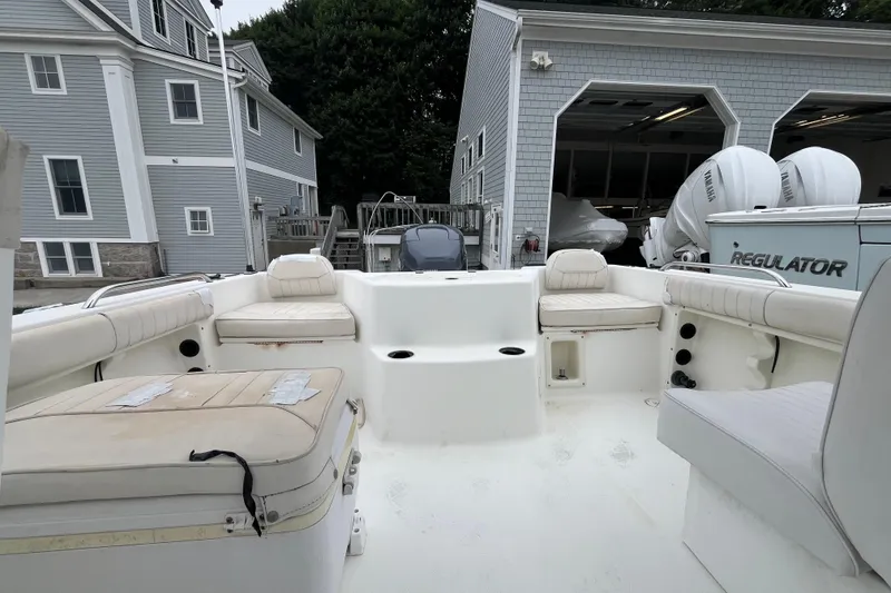 Slide: The Image of 2002 Hydra-Sports 202 DC boat interior with seating, docked near gray buildings. - 19