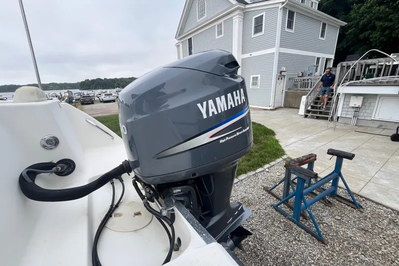 Slide: The Image of 2002 Hydra-Sports 202 DC with Yamaha outboard motor near a coastal house. - 26