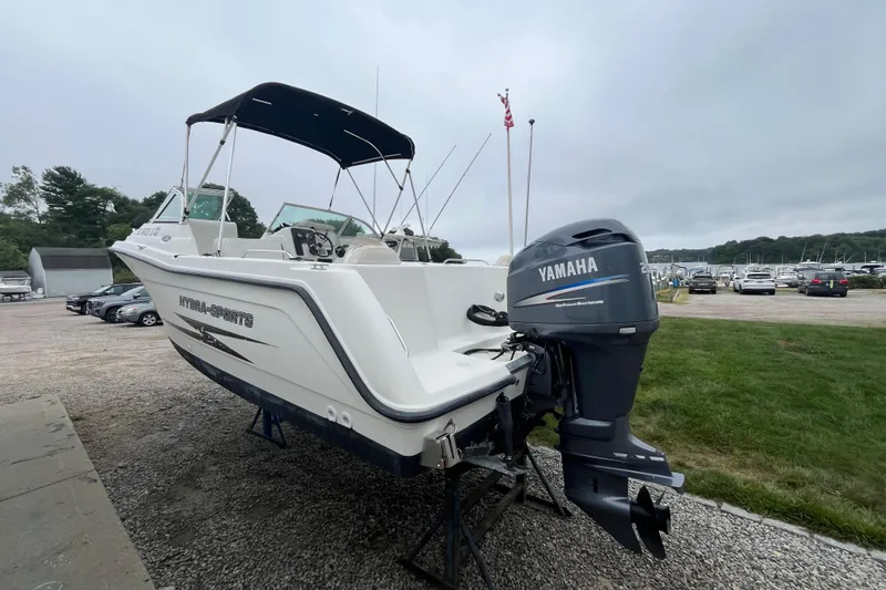 Slide: The Image of 2002 Hydra-Sports 202 DC boat with Yamaha outboard motor, parked on gravel near marina. - 4