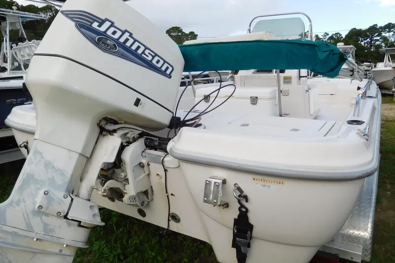 The Image of 2002 Fishmaster 22 BAY boat with Johnson outboard motor, docked on grass. - 1