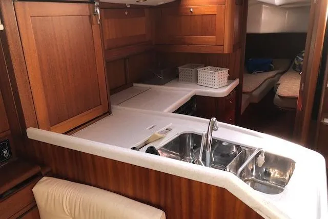Slide: The Image of Interior of 1999 Sweden Yachts 45, featuring a wooden kitchen with sink and seating area. - 11
