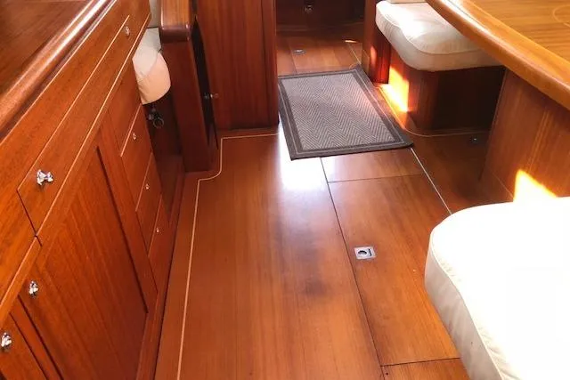 Slide: The Image of Interior of 1999 Sweden Yachts 45, featuring polished wood flooring and cushioned seating. - 17