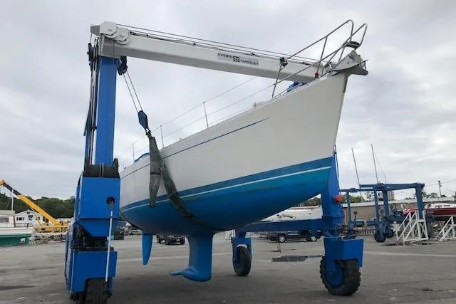 Slide: The Image of Sailboat Sweden Yachts 45, 1999 model, lifted by a blue boat hoist in a marina. - 27
