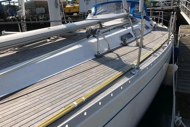 Slide: The Image of 1999 Sweden Yachts 45 sailboat docked, showcasing sleek deck design and nautical features. - 5