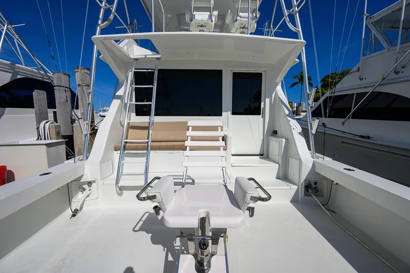 Slide: The Image of 1998 Viking 53 Convertible yacht deck with fishing chair and ladder under clear blue sky. - 10