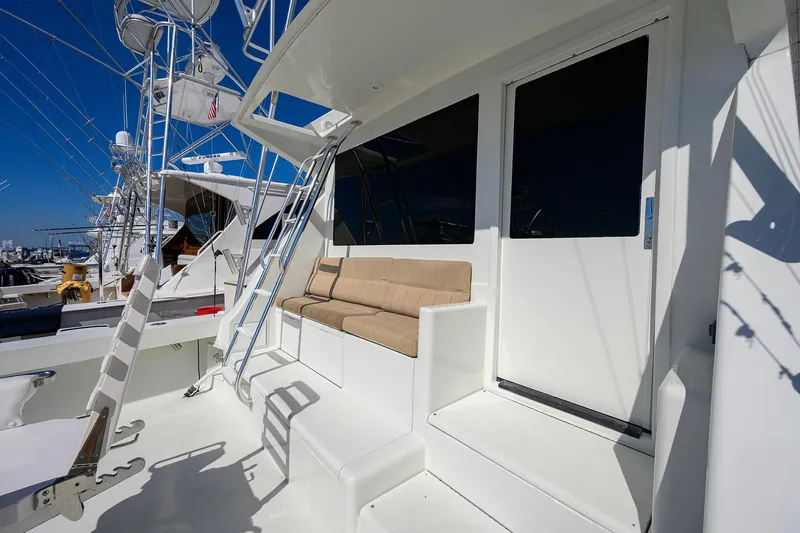 Slide: The Image of 1998 Viking 53 Convertible yacht deck with seating and ladder under clear blue sky. - 14