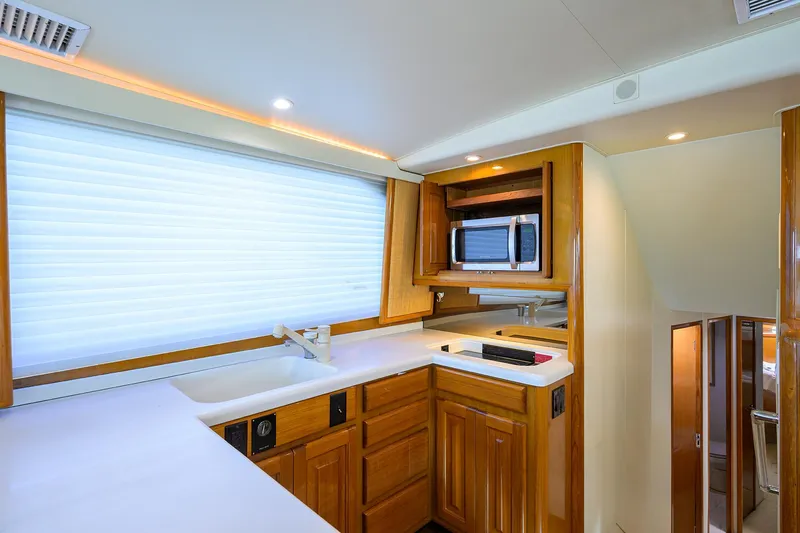 Slide: The Image of Interior of 1998 Viking 53 Convertible yacht kitchen with wood cabinets and modern appliances. - 26