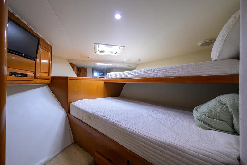 Slide: The Image of 1998 Viking 53 Convertible yacht cabin with bunk beds and a TV. - 27