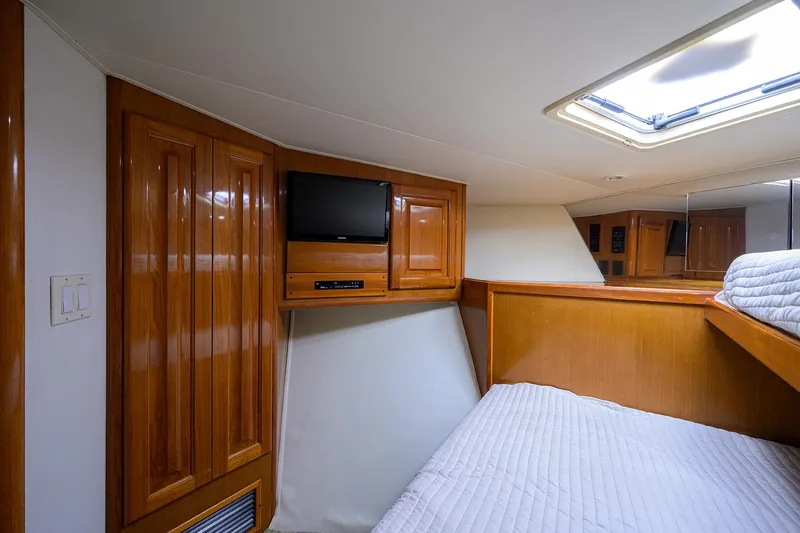 Slide: The Image of 1998 Viking 53 Convertible yacht cabin with wood paneling, TV, and skylight. - 28