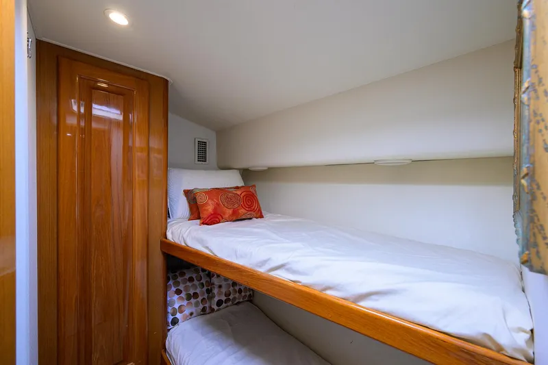 Slide: The Image of Bunk beds in 1998 Viking 53 Convertible yacht cabin with wooden accents and cozy bedding. - 29