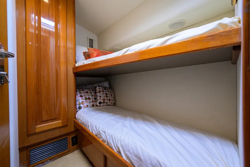 Slide: The Image of Bunk beds in 1998 Viking 53 Convertible yacht cabin with wooden finish and cozy bedding. - 30