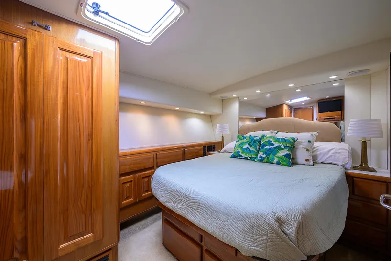 Slide: The Image of Luxurious bedroom interior of 1998 Viking 53 Convertible yacht with elegant wood finishes. - 32