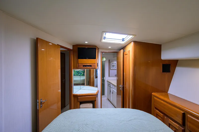 Slide: The Image of Interior of 1998 Viking 53 Convertible yacht, featuring wood finishes and a cozy cabin. - 34