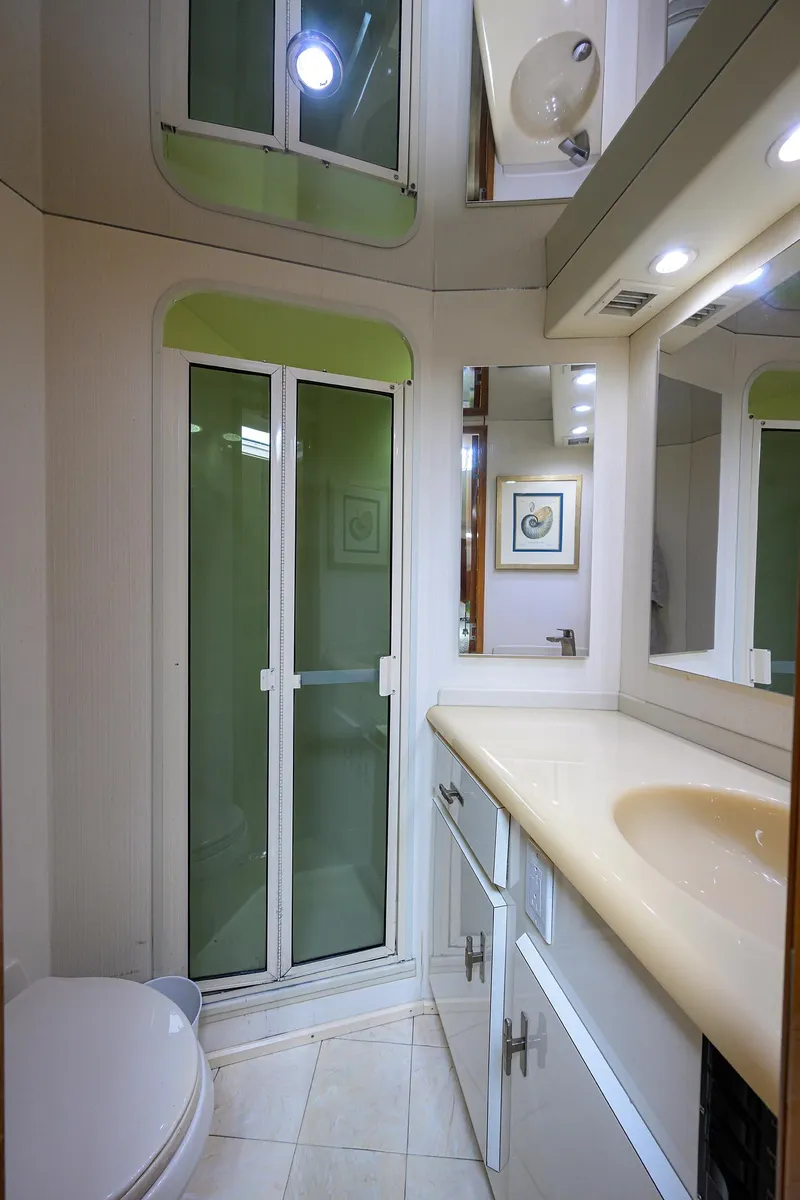 Slide: The Image of Bathroom interior of a 1998 Viking 53 Convertible yacht, featuring a shower and vanity. - 36