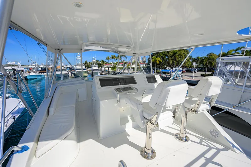 Slide: The Image of 1998 Viking 53 Convertible yacht helm with white seating and marina view. - 39