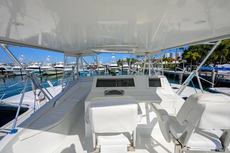 Slide: The Image of 1998 Viking 53 Convertible yacht interior with white seating at marina. - 40