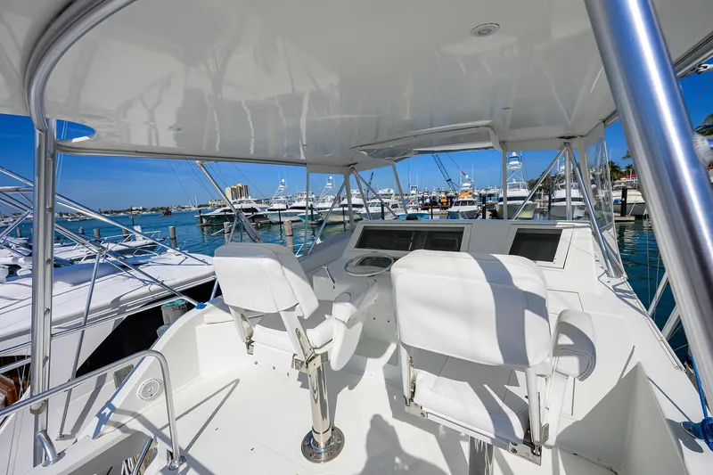 Slide: The Image of 1998 Viking 53 Convertible yacht helm with dual seats, docked in a marina. - 41