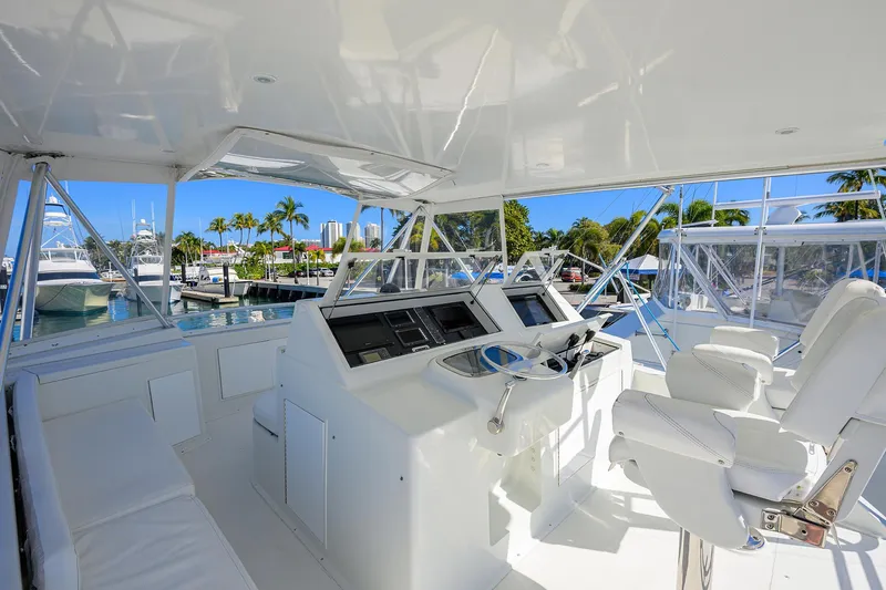 Slide: The Image of 1998 Viking 53 Convertible yacht helm with white seating and marina view. - 44