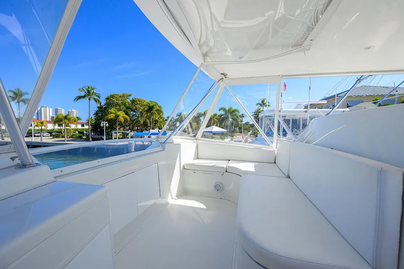 Slide: The Image of Luxurious 1998 Viking 53 Convertible yacht interior with white seating and scenic marina view. - 47