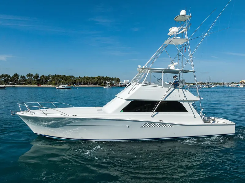 Slide: The Image of 1998 Viking 53 Convertible yacht cruising on clear blue water. - 5