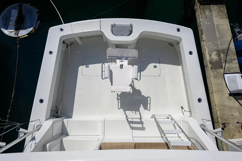 Slide: The Image of 1998 Viking 53 Convertible yacht deck, featuring a spacious fishing area and ladder access. - 7