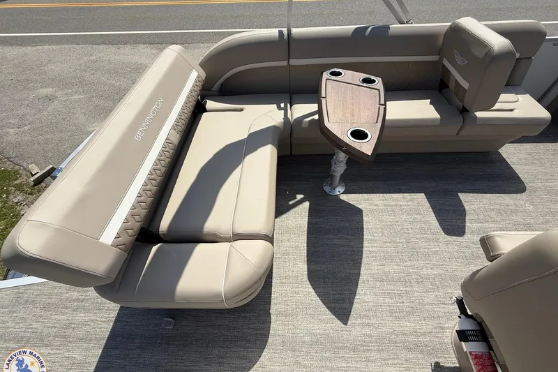Slide: The Image of 2025 Bennington 22ML boat interior with beige seating and a wooden table. - 14