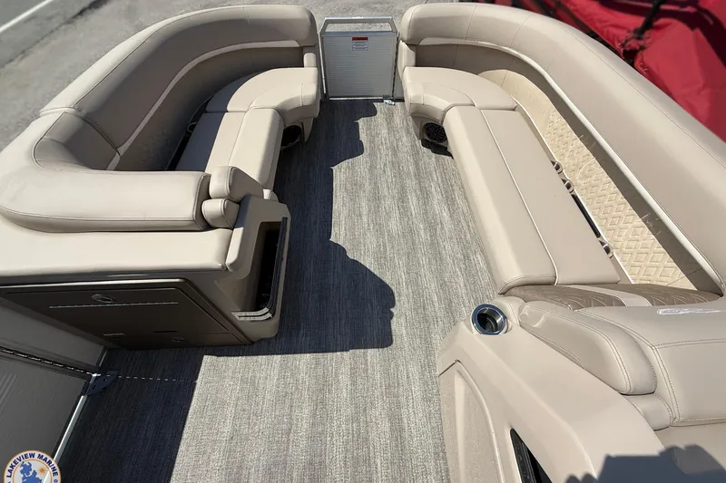 Slide: The Image of 2025 Bennington 22ML pontoon boat interior with beige seating and carpeted flooring. - 5