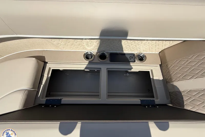 Slide: The Image of 2025 Bennington 22ML boat interior with storage compartment and cup holders. - 8