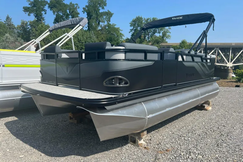Slide: The Image of 2026 Tahoe Pontoon 1980 CRUISE boat with sleek design, parked outdoors on gravel. - 1
